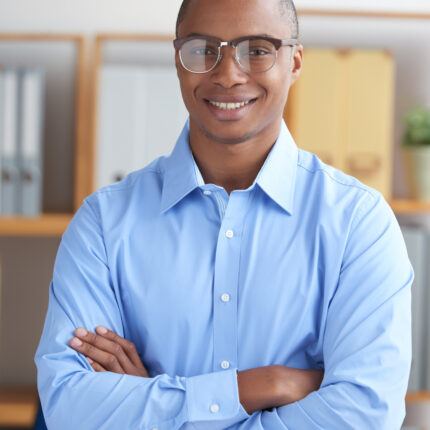 Portrait of confident smiling businessman standing with his arms crossed